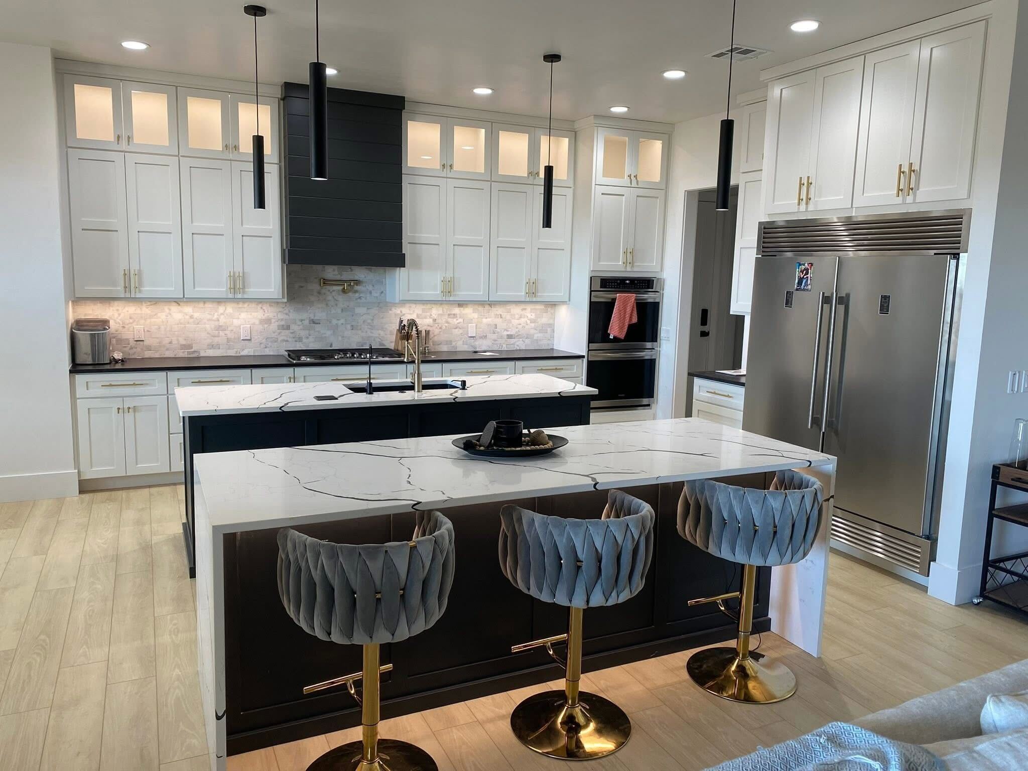 Modern white kitchen with marble island and pendant lighting