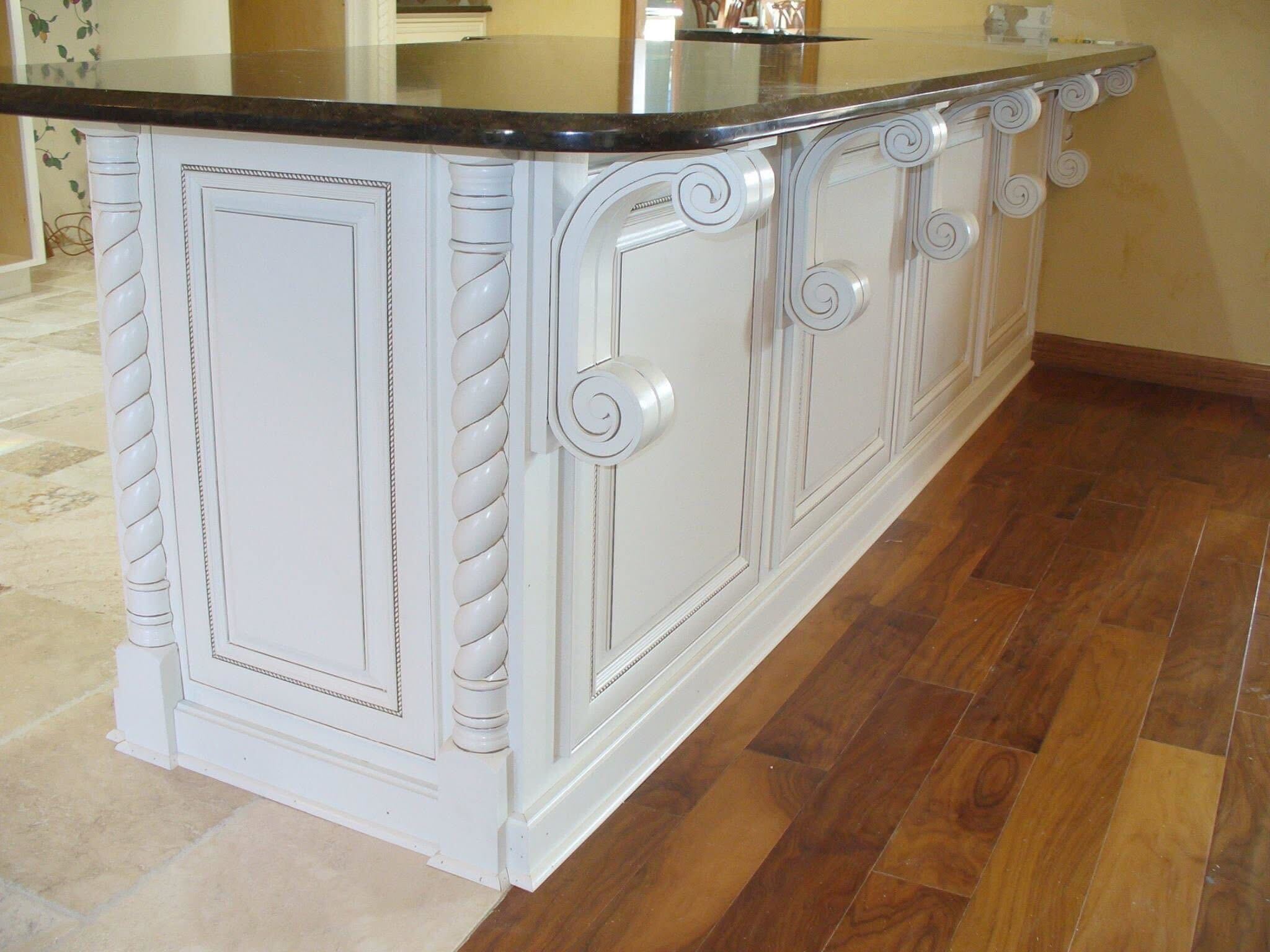 Ornate white kitchen island with rope columns and scroll details